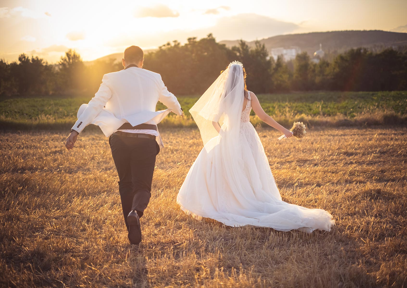wedding photographers - Bride and Groom running near dusk